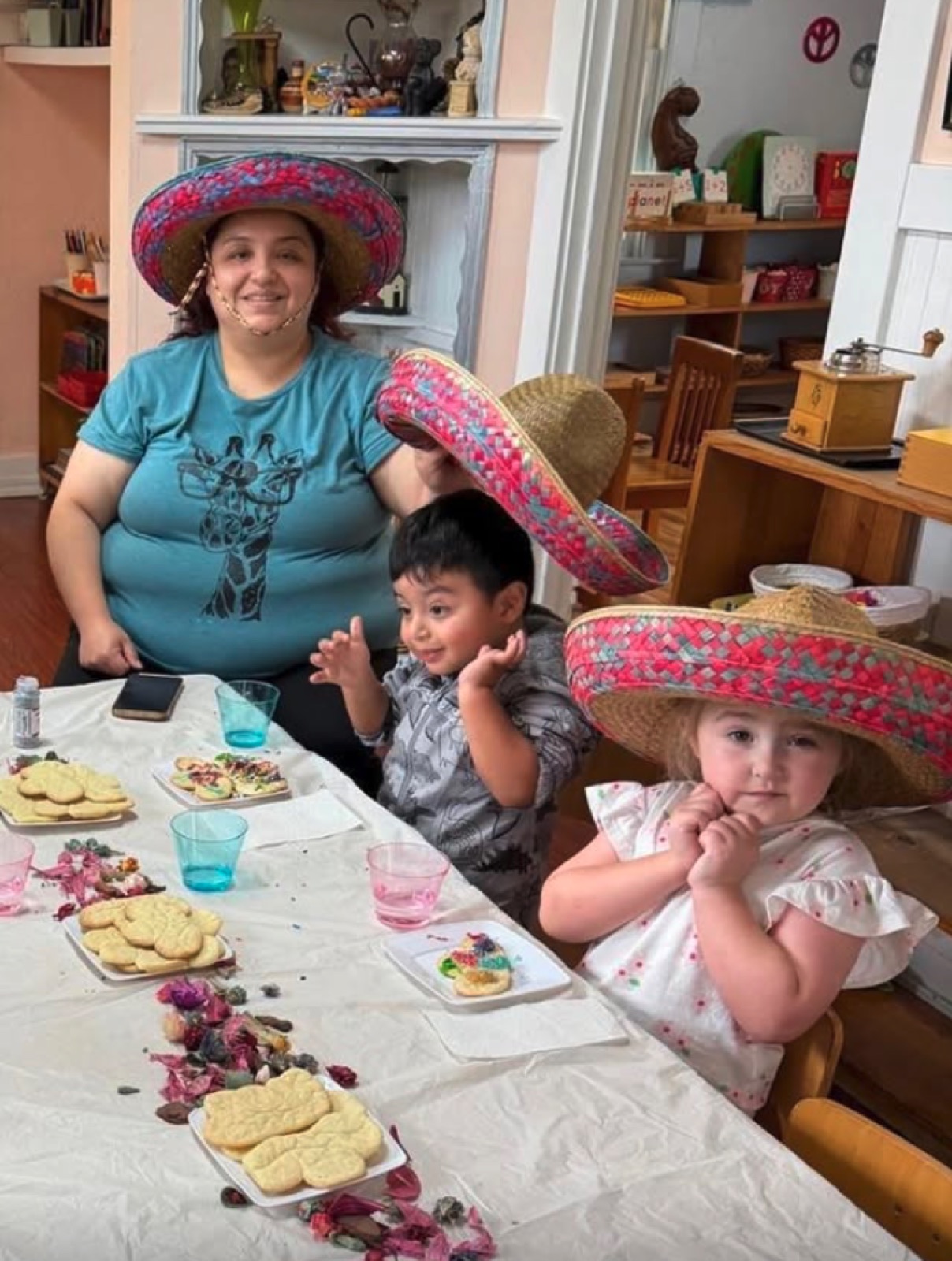 Parents and children sitting side by side at a classroom table, making art together
