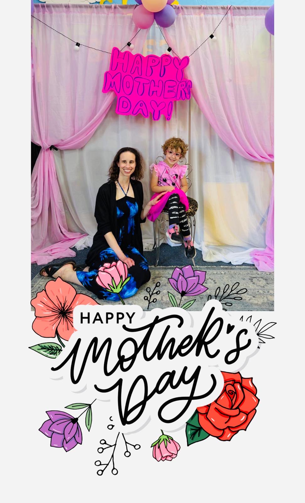 A mother and child pose in the pink Mother's Day photo booth
